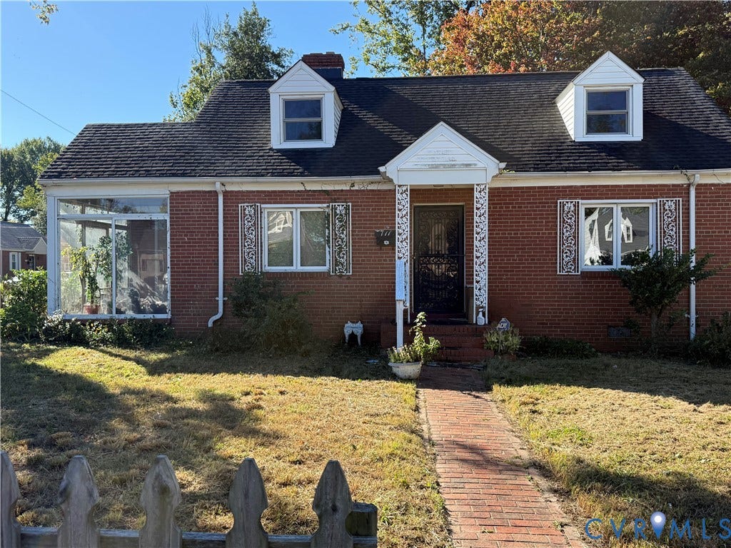 711 Ratcliffe Avenue, Richmond, VA 23222 Cape Cod-style residence featuring a red brick exterior, two dormer windows, a covered front entryway with decorative metal supports, and a brick walkway