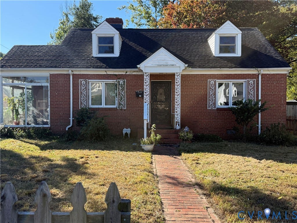 711 Ratcliffe Avenue, Richmond, VA 23222 Red brick exterior featuring a shingled roof, two dormer windows, decorative window shutters, and an enclosed side porch