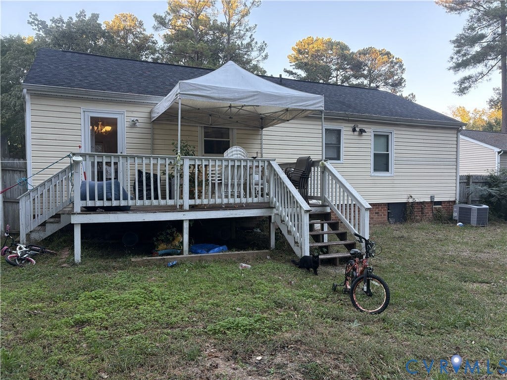 3207 Roland View Terrace, Chester, VA 23831 Exterior elevation featuring light-colored horizontal siding, a gable roof with asphalt shingles, a raised wooden deck with balustrades, and a brick foundation footer