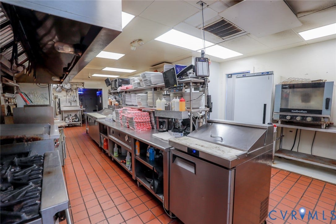 700 Jordan Point Road, North Prince George, VA 23860 Commercial kitchen featuring stainless steel prep stations, industrial-grade range equipment, a professional exhaust hood system, a dedicated convection oven, and durable tile flooring