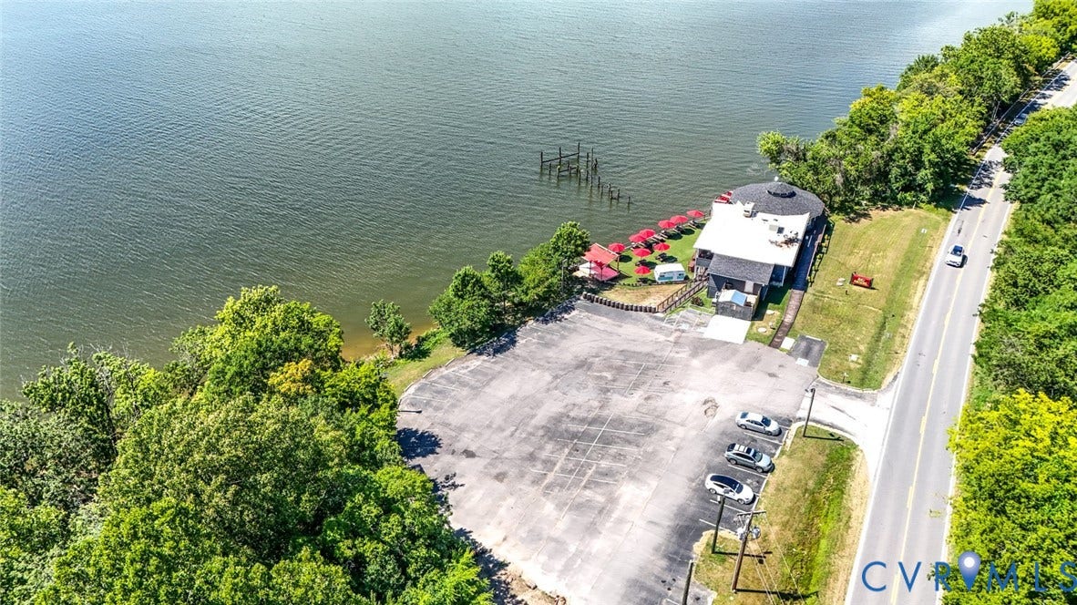 700 Jordan Point Road, North Prince George, VA 23860 Waterfront property featuring a paved parking area, mature trees, and direct access to the shoreline