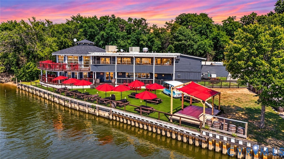 700 Jordan Point Road, North Prince George, VA 23860 Waterfront structure featuring a multi-level deck, wood-bulkhead shoreline, expansive artificial turf lawn, and a covered outdoor platform