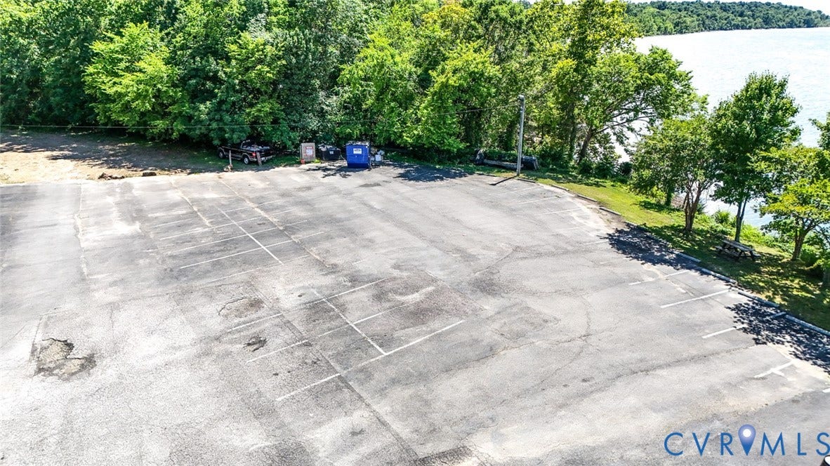 700 Jordan Point Road, North Prince George, VA 23860 Asphalt-paved parking area featuring marked spaces, perimeter mature trees, and waterfront proximity