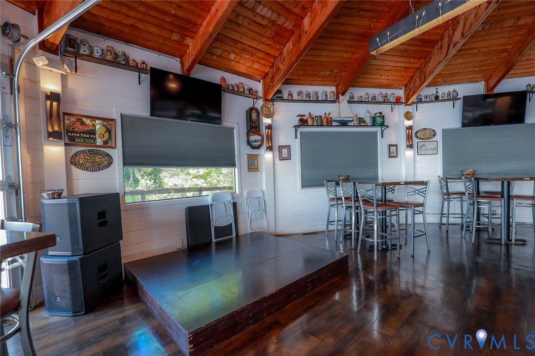 700 Jordan Point Road, North Prince George, VA 23860 Vaulted ceiling with exposed wood beams, wood-finish flooring, white horizontal wall paneling, and built-in wall shelving