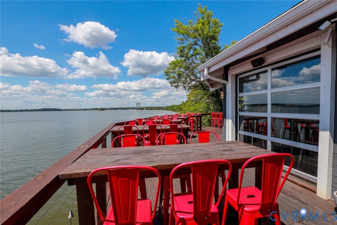 700 Jordan Point Road, North Prince George, VA 23860 Waterfront deck featuring wood-plank flooring, a wood railing, and a multi-paneled garage-style door system