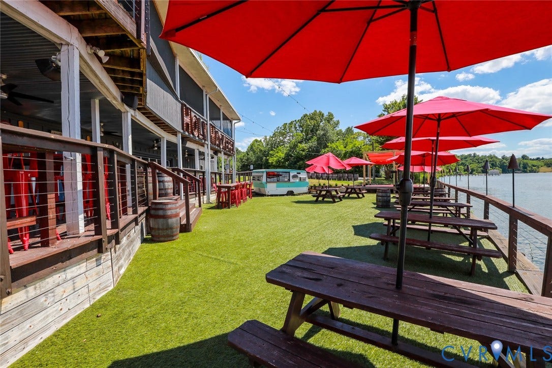 700 Jordan Point Road, North Prince George, VA 23860 Waterfront outdoor space featuring a tiered wood deck, synthetic turf surface, metal cable railings, and multi-level structural support beams
