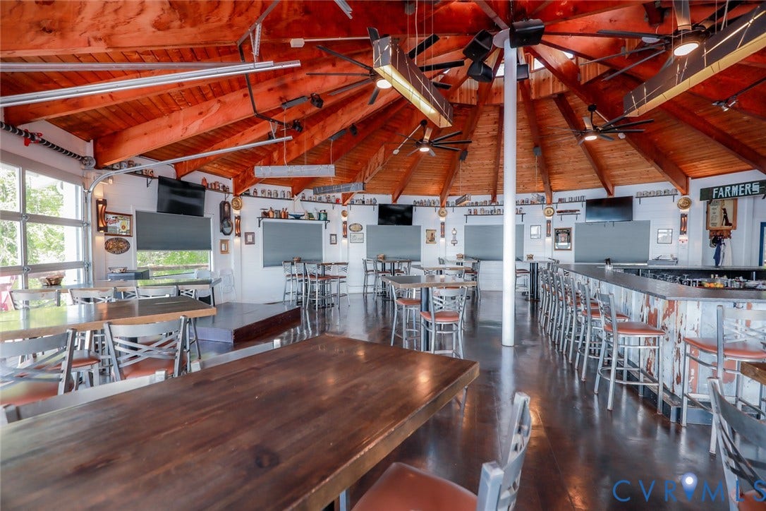 700 Jordan Point Road, North Prince George, VA 23860 Circular rotunda space featuring vaulted exposed wood-beam ceilings, multiple ceiling fans, integrated bar area with built-in counter, and glass garage-style doors