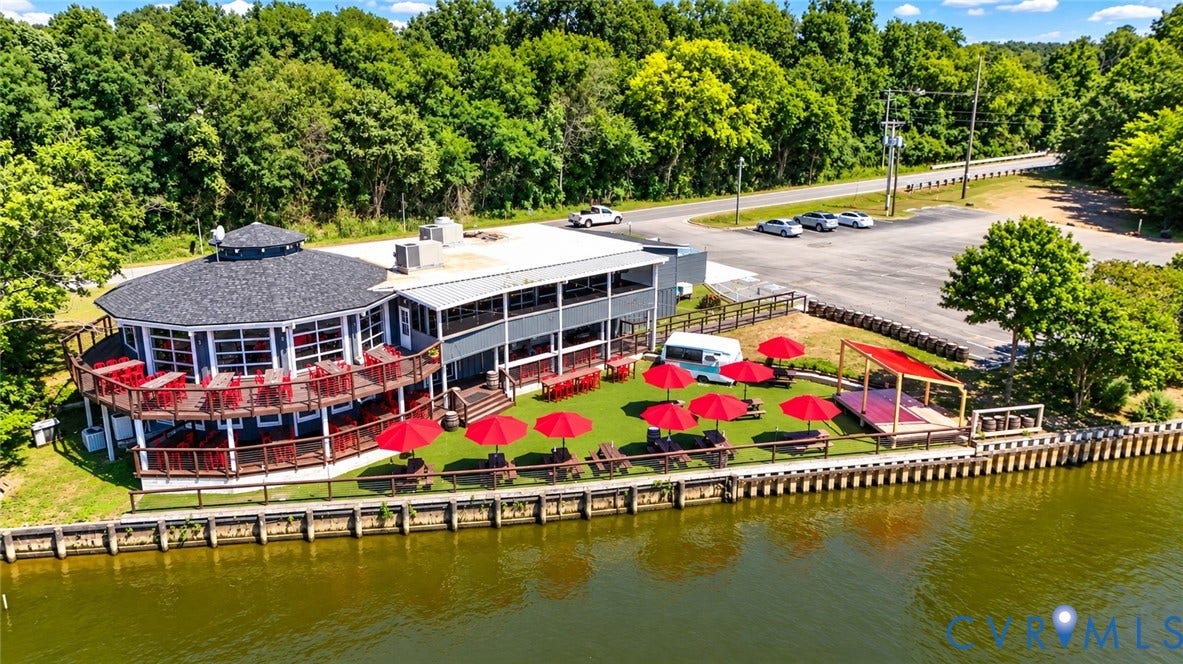 700 Jordan Point Road, North Prince George, VA 23860 Waterfront property featuring a multi-level deck, shingle roof, paved surface parking, and a bulkhead