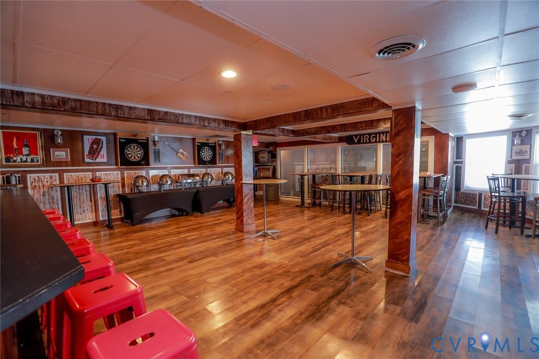 700 Jordan Point Road, North Prince George, VA 23860 Finished lower level featuring wood-finish flooring, wood-paneled walls, and decorative columns with a faux wood grain finish