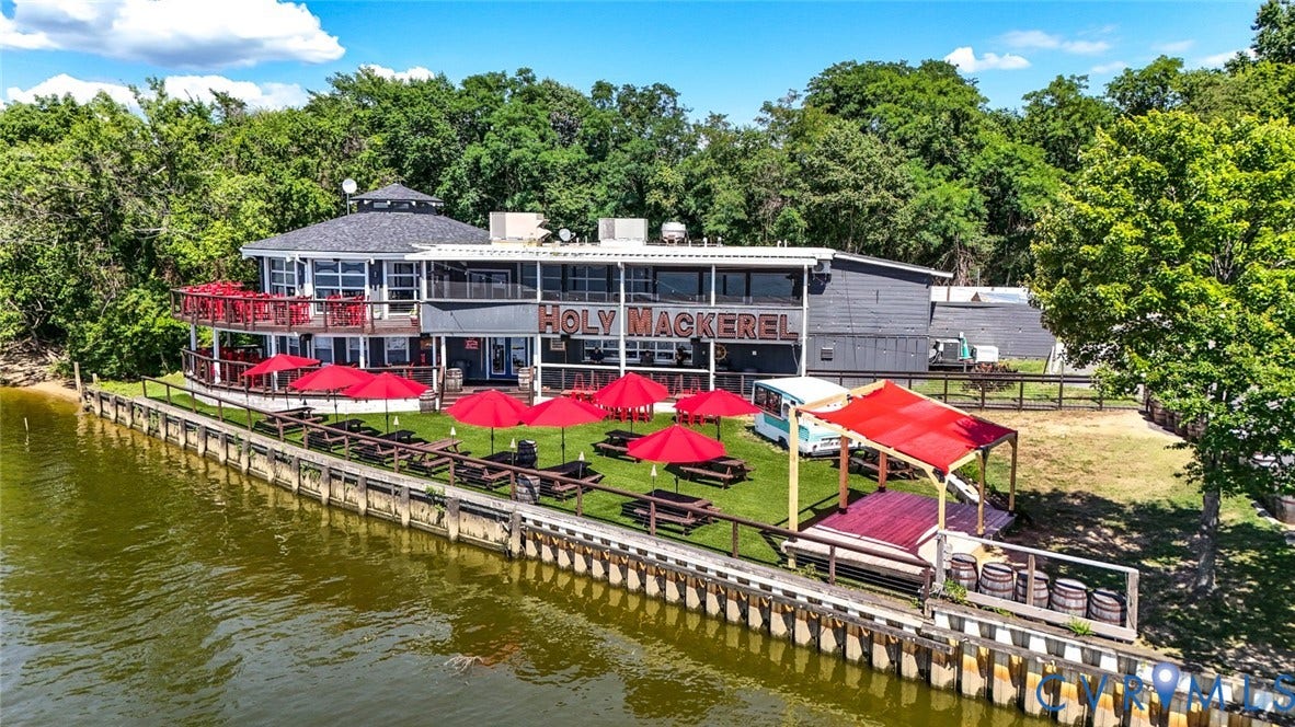 700 Jordan Point Road, North Prince George, VA 23860 Waterfront commercial property featuring direct bulkhead access, a multi-level deck, expansive lawn, and mature perimeter trees
