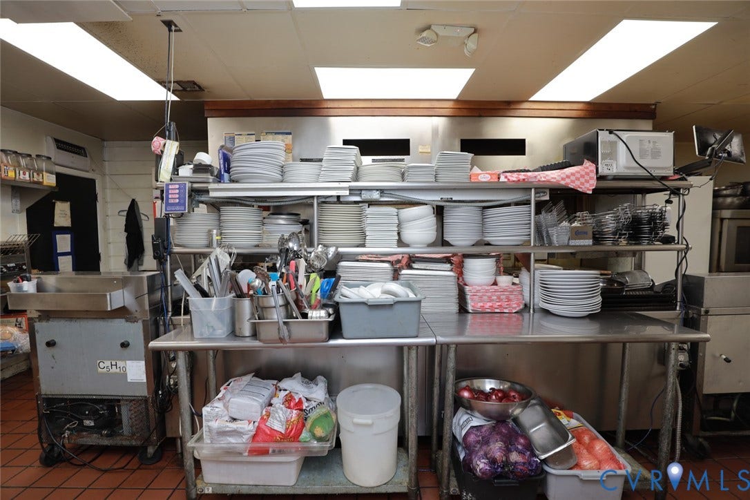 700 Jordan Point Road, North Prince George, VA 23860 Commercial kitchen workspace featuring stainless steel preparation counters, integrated shelving units, and ceramic tile flooring