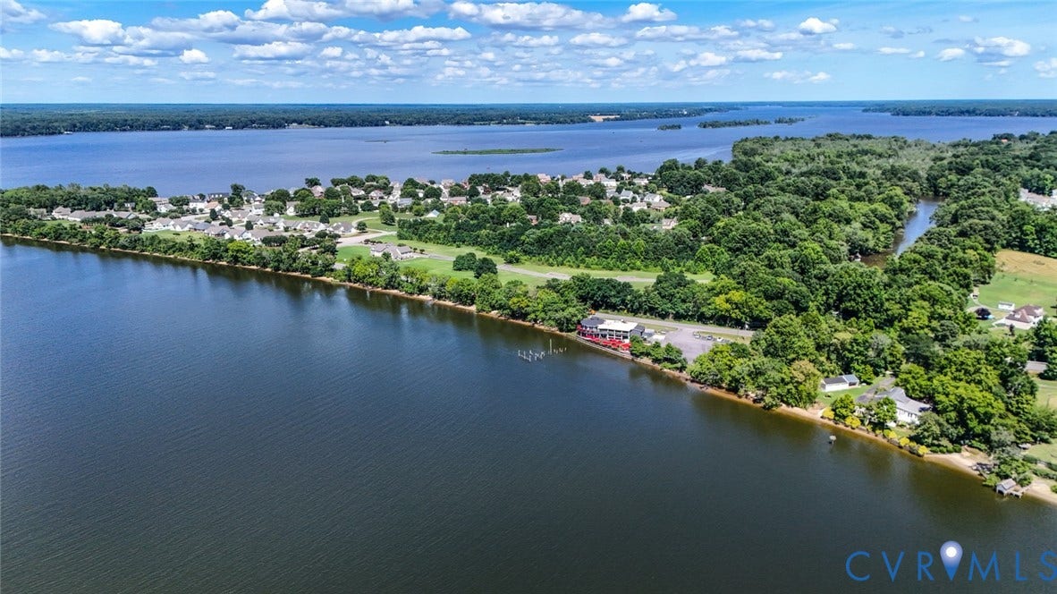 700 Jordan Point Road, North Prince George, VA 23860 Aerial perspective of waterfront property featuring extensive shoreline, private pier, paved driveway, and mature landscaping