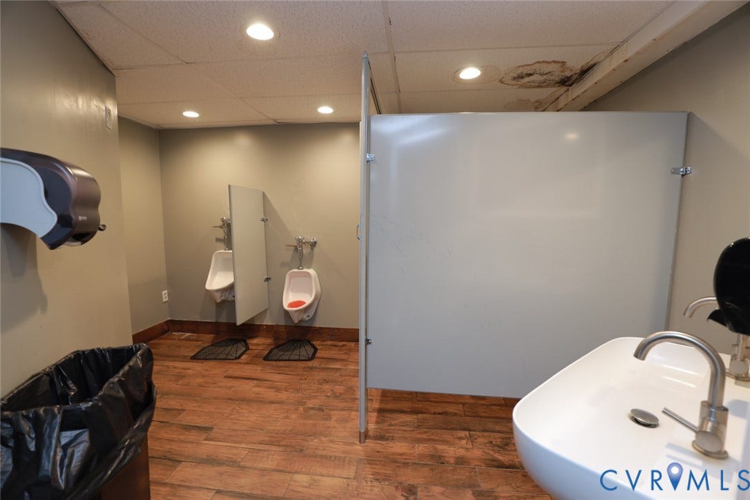 700 Jordan Point Road, North Prince George, VA 23860 Restroom featuring wood-finish flooring, recessed lighting, wall-mounted urinals with privacy partitions, and a vessel sink with a metal faucet