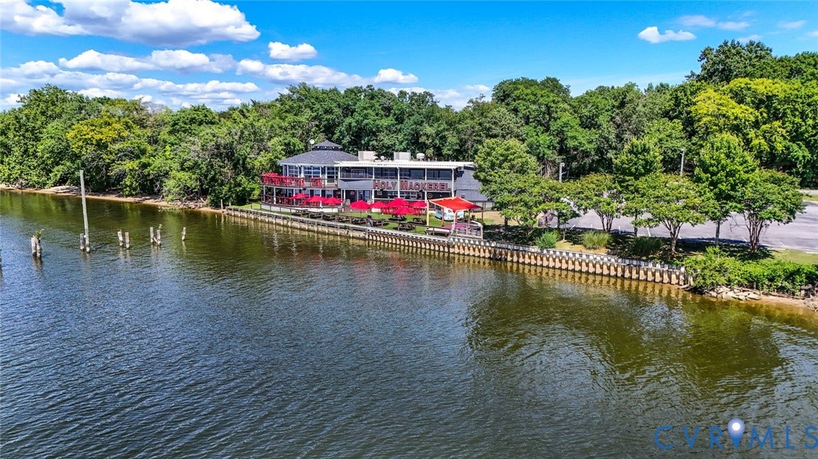 700 Jordan Point Road, North Prince George, VA 23860 Waterfront commercial property featuring bulkheaded shoreline, multi-level building architecture, expansive paved parking area, and mature perimeter landscaping