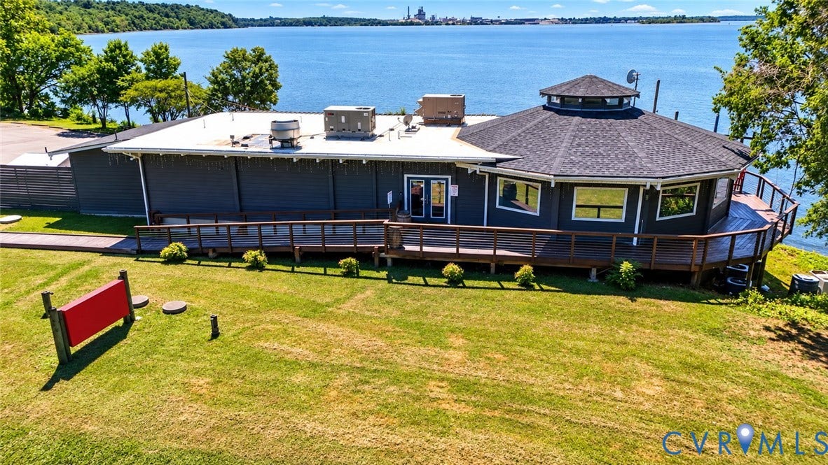 700 Jordan Point Road, North Prince George, VA 23860 Waterfront property featuring a wraparound wood deck, exterior wood siding, a multi-faceted roofline, and expansive grounds