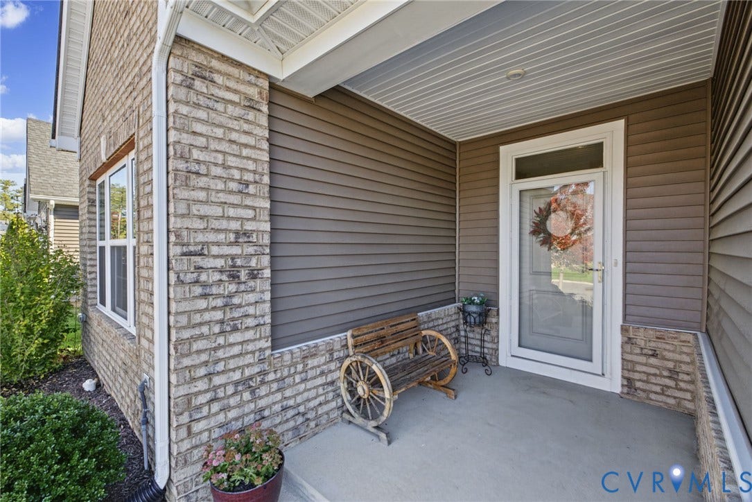 6525 Liddy Circle, Glen Allen, VA 23060 Covered entryway featuring brick detailing and a glass-paneled entry door with an overhead transom window.