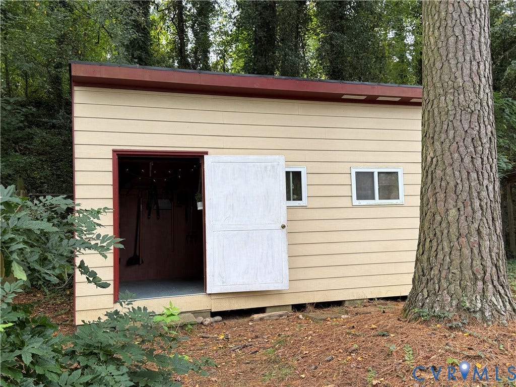 237 Spring Drive, Franklin, VA 23834 Detached structure featuring horizontal lap siding, a shed roof, two rectangular sliding windows, and a swinging entrance door