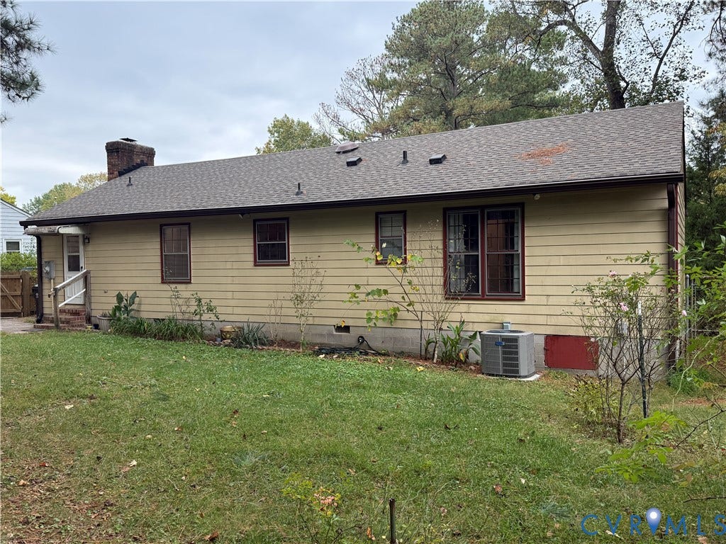 237 Spring Drive, Franklin, VA 23834 Exterior rear elevation featuring horizontal lap siding, a pitched asphalt shingle roof, a masonry chimney, and established perimeter landscaping