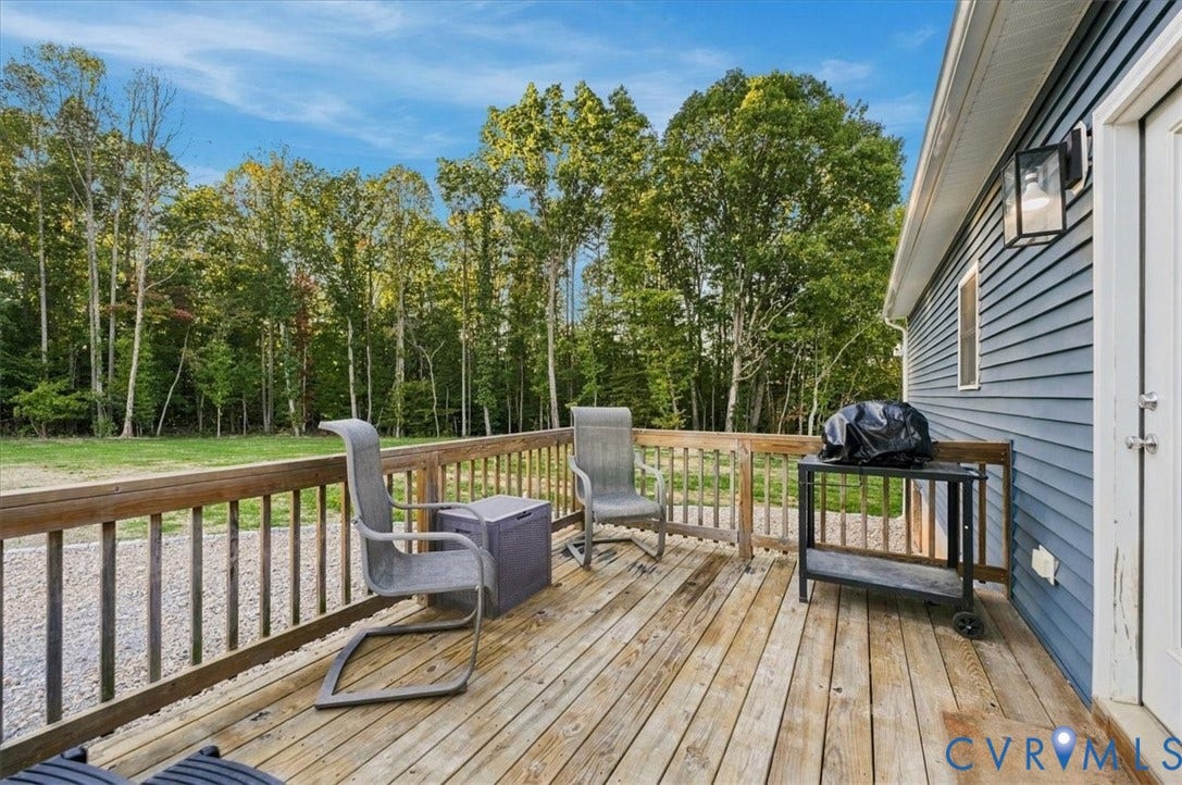 11880 Fosters Lane, Amelia, VA 23002 Blue siding exterior featuring a raised wood deck, stone-filled landscaping, and concrete hardscaping