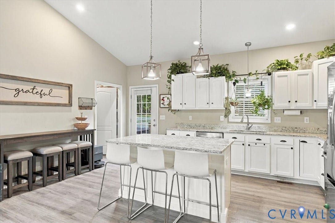 11880 Fosters Lane, Amelia, VA 23002 Kitchen featuring white cabinetry, stone-surface countertops, center island with seating, vaulted ceiling, and wood-finish flooring
