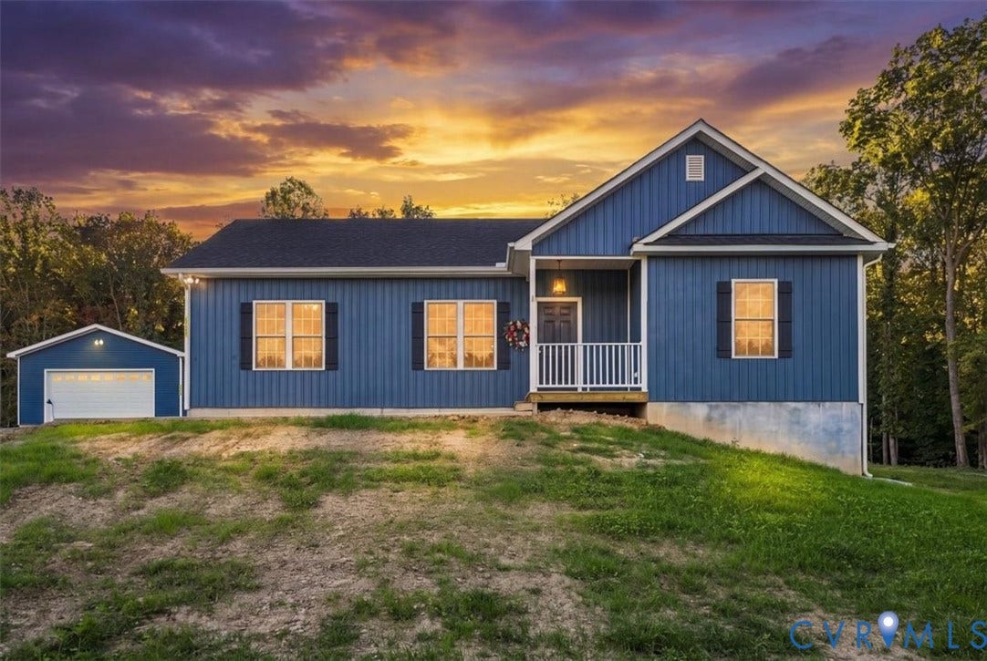 11880 Fosters Lane, Amelia, VA 23002 Single-story residence featuring blue vertical siding, dark shutters, a covered front porch with white railing, and a detached one-car garage
