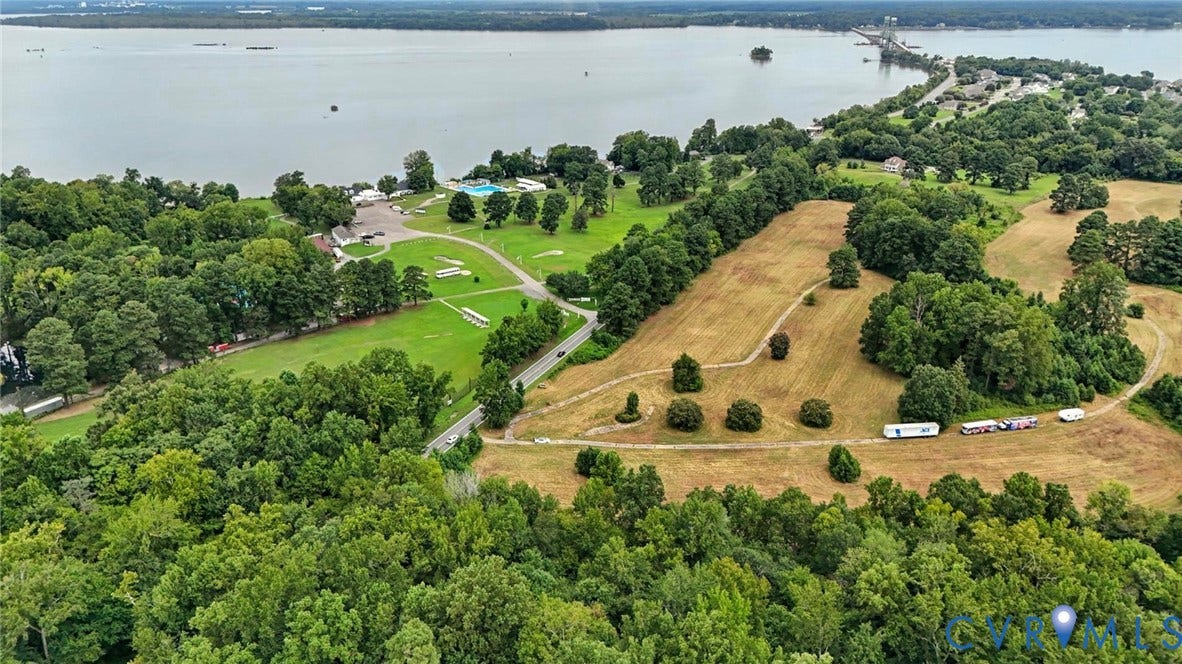 1100 Jordan Point Road, North Prince George, VA 23860 Aerial perspective featuring expansive acreage, mature tree clusters, open grass fields, and proximity to the shoreline