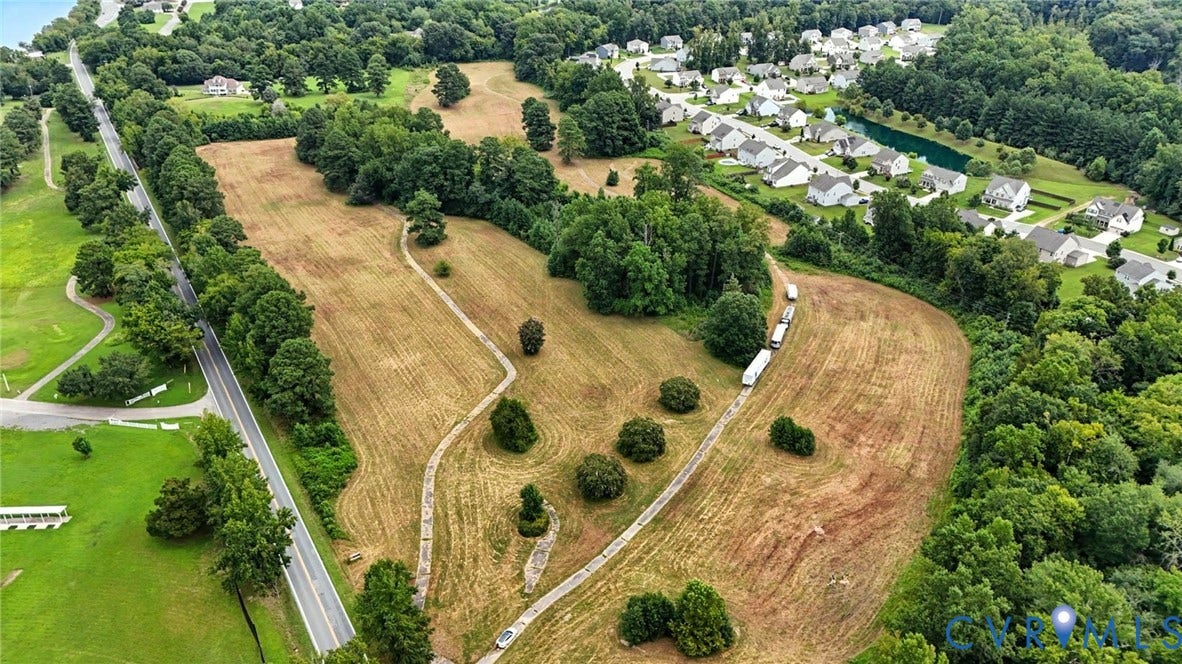 1100 Jordan Point Road, North Prince George, VA 23860 Expansive land parcel featuring rolling topography, mature tree clusters, and paved path access