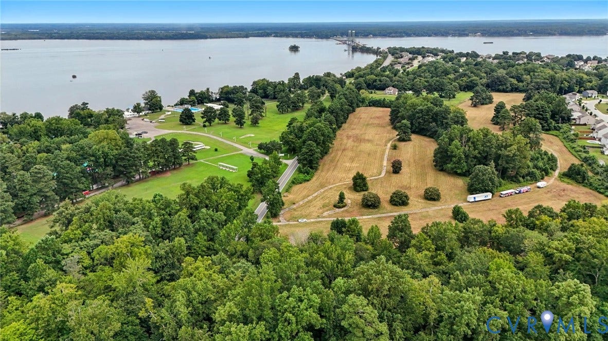 1100 Jordan Point Road, North Prince George, VA 23860 Aerial perspective of expansive acreage featuring mature woodland, open grassy meadows, and prominent water frontage