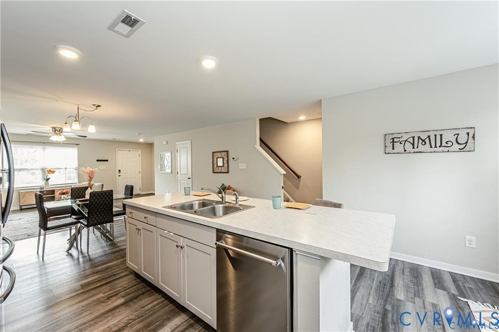 1324 Stone Ridge Park Loop, Henrico, VA 23228 Kitchen island with a dual-basin stainless steel sink and stainless steel dishwasher, light-toned cabinetry, recessed lighting, and wood-finish flooring