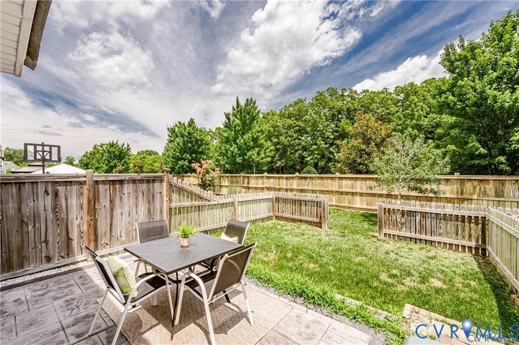 1324 Stone Ridge Park Loop, Henrico, VA 23228 Rear yard featuring a stamped concrete patio, wood privacy fencing, and a grass lawn
