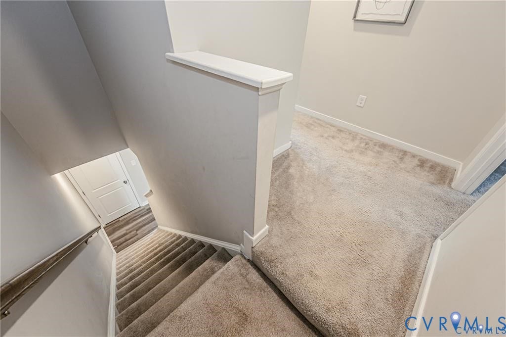 1324 Stone Ridge Park Loop, Henrico, VA 23228 Staircase featuring neutral carpeting, a painted half-wall with a cap, and a minimalist metal handrail