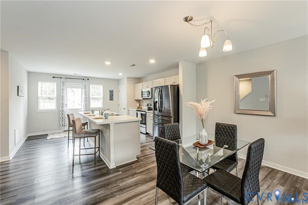 1324 Stone Ridge Park Loop, Henrico, VA 23228 Kitchen featuring a central island with countertop seating, wood-finish flooring, white cabinetry, stainless steel appliances, and recessed lighting