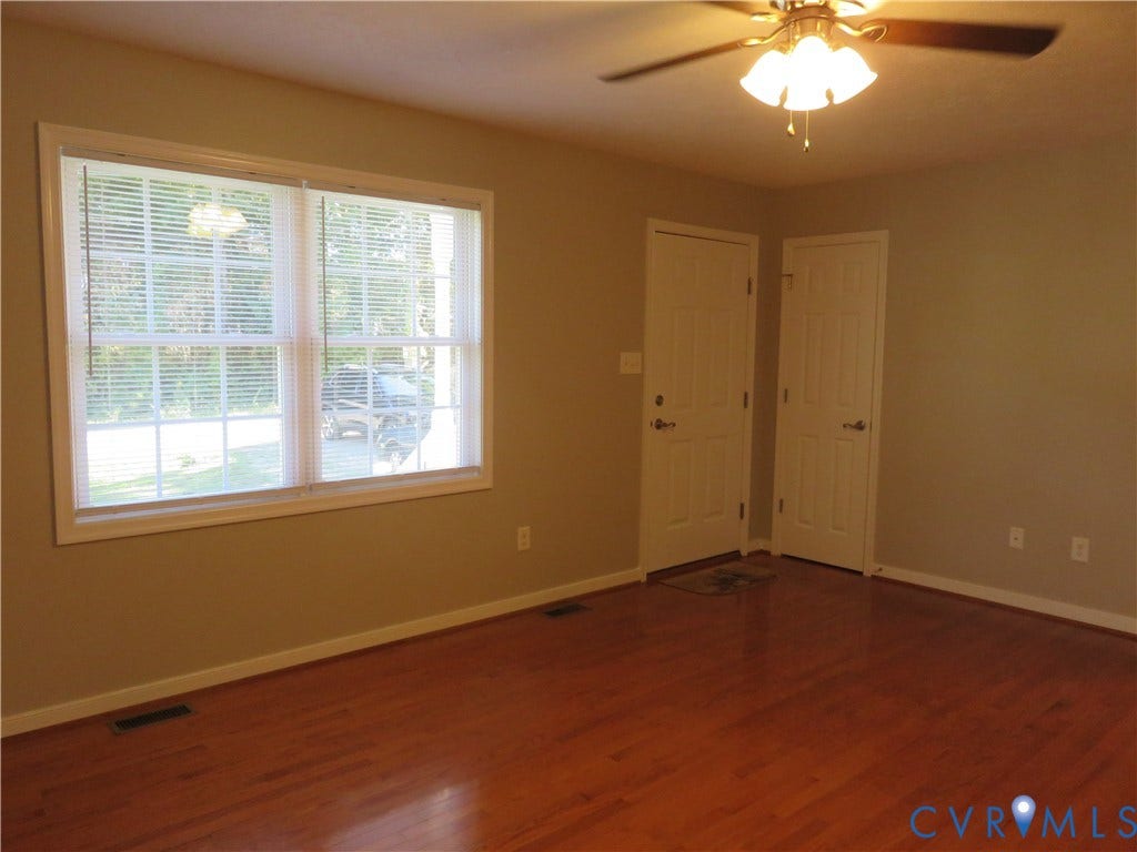 14 N Kalmia Avenue, Henrico, VA 23075 Room featuring wood-finish flooring, a large multi-pane window, two white paneled doors, and an attached ceiling fan with light fixture