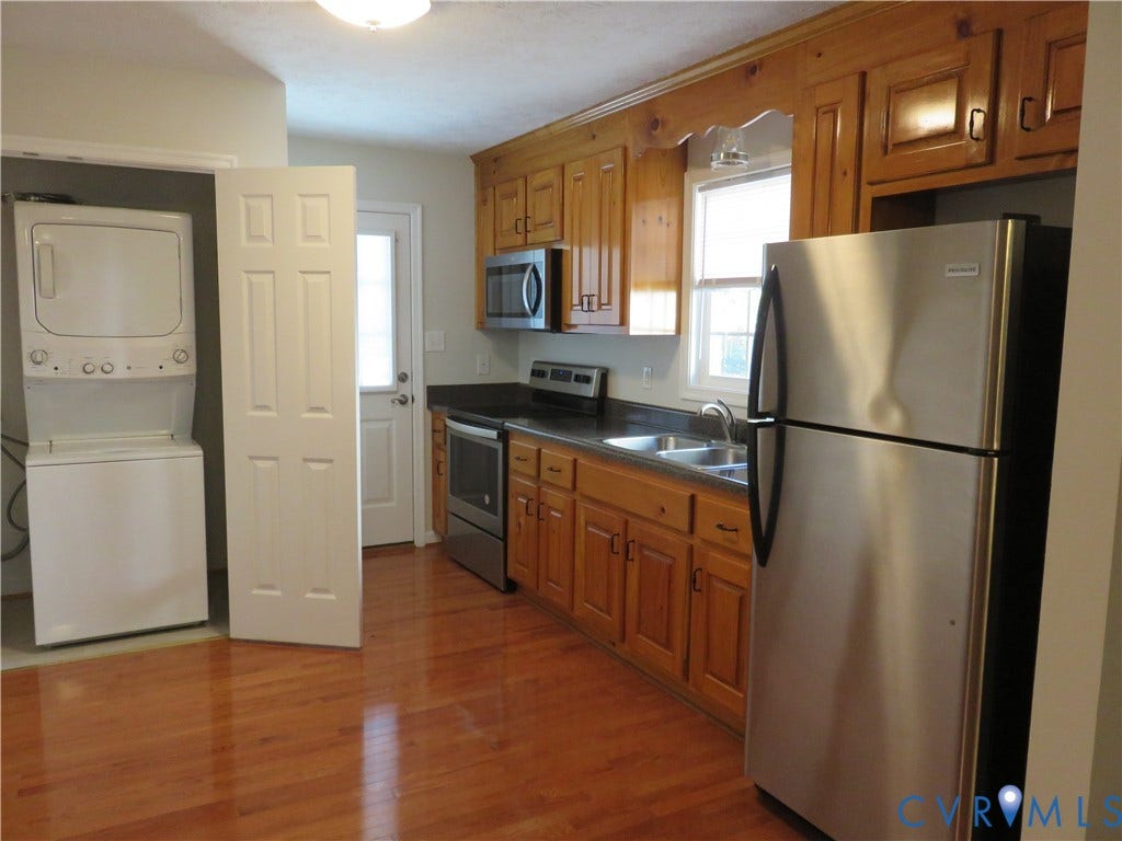 14 N Kalmia Avenue, Henrico, VA 23075 Kitchen featuring wooden cabinetry, stainless steel appliances, dark countertops, and wood-finish flooring, complemented by a dedicated laundry area