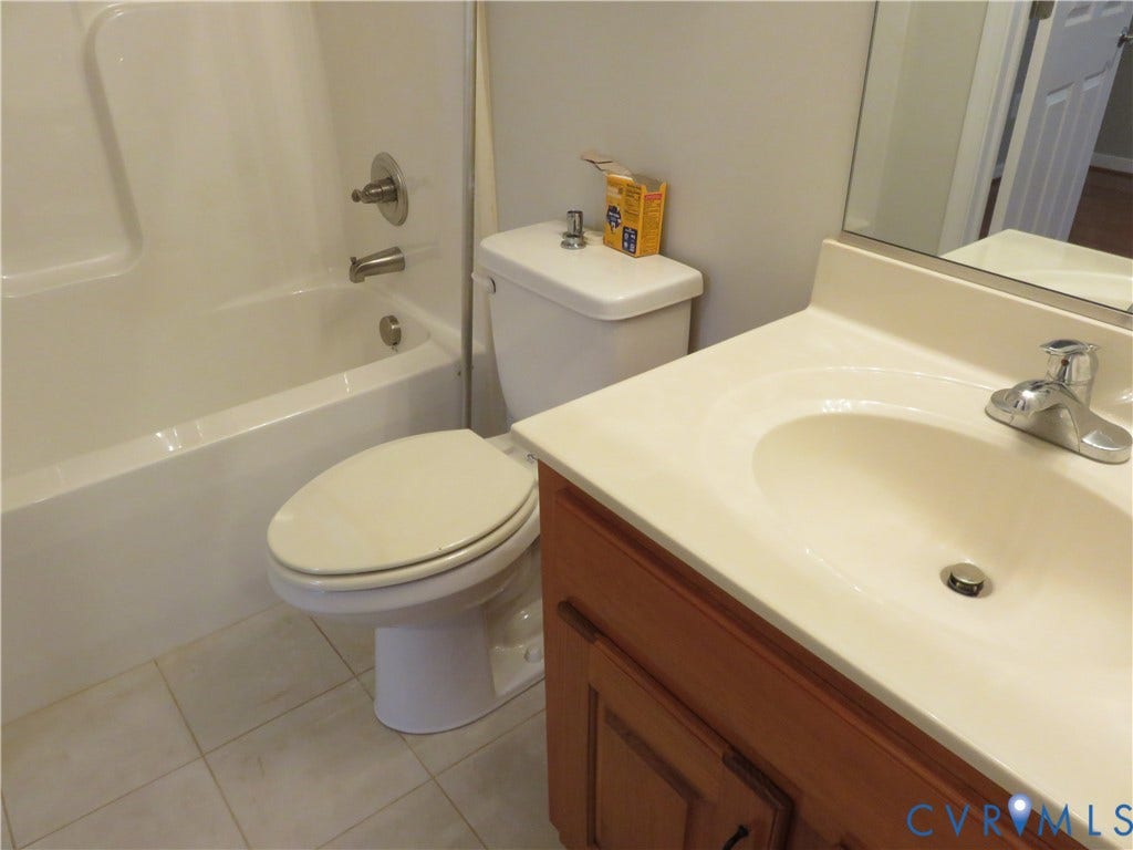 14 N Kalmia Avenue, Henrico, VA 23075 Bathroom featuring a wood-finish vanity with a molded countertop, integrated sink, chrome-finish faucet, and a tub-shower combination with tile flooring