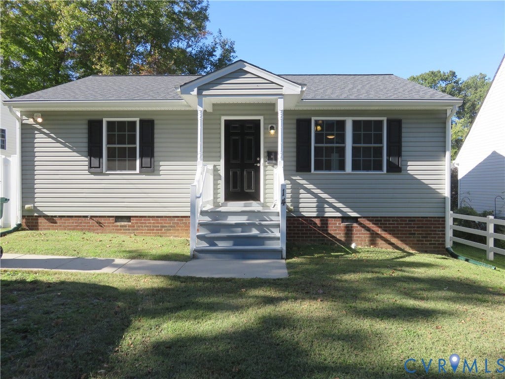 14 N Kalmia Avenue, Henrico, VA 23075 Single-story exterior featuring light-toned vinyl siding, brick foundation, dark-toned shutters, and a covered front stoop with white railings