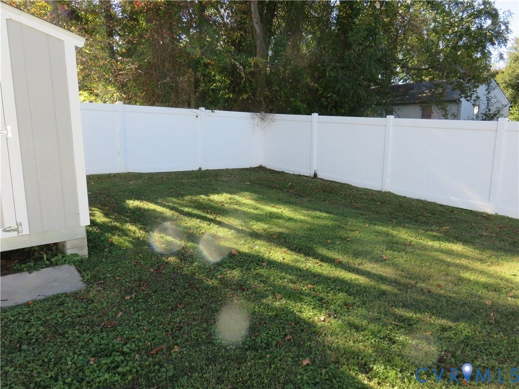 14 N Kalmia Avenue, Henrico, VA 23075 Backyard featuring a white vinyl privacy fence and a detached storage structure on a concrete foundation