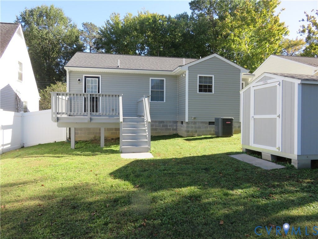 14 N Kalmia Avenue, Henrico, VA 23075 Rear exterior featuring gray vinyl siding, an elevated wood deck with stairs, a detached storage shed, and a white privacy fence