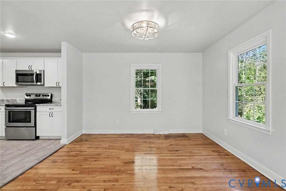 2511 Mill Road, Powhatan, VA 23139 Open-concept space featuring wood-finish flooring, white cabinetry, stainless steel appliances, dual-pane windows, and a decorative flush-mount ceiling fixture