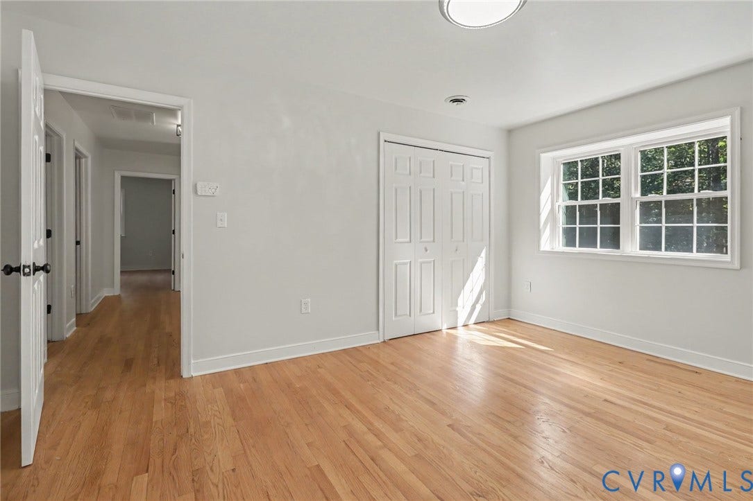 2511 Mill Road, Powhatan, VA 23139 Room featuring wood-finish flooring, crisp neutral wall paint, white six-panel closet doors, and multi-pane windows with white trim
