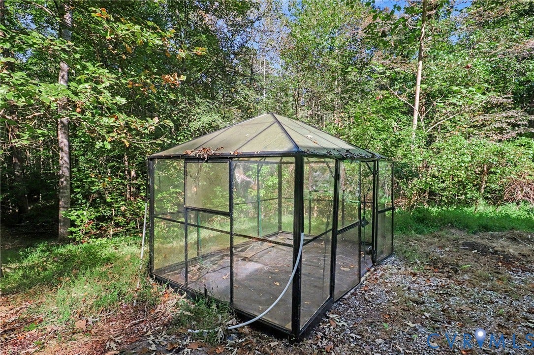 2511 Mill Road, Powhatan, VA 23139 Free-standing greenhouse featuring black metal framing, glass paneling, and a pitched roof