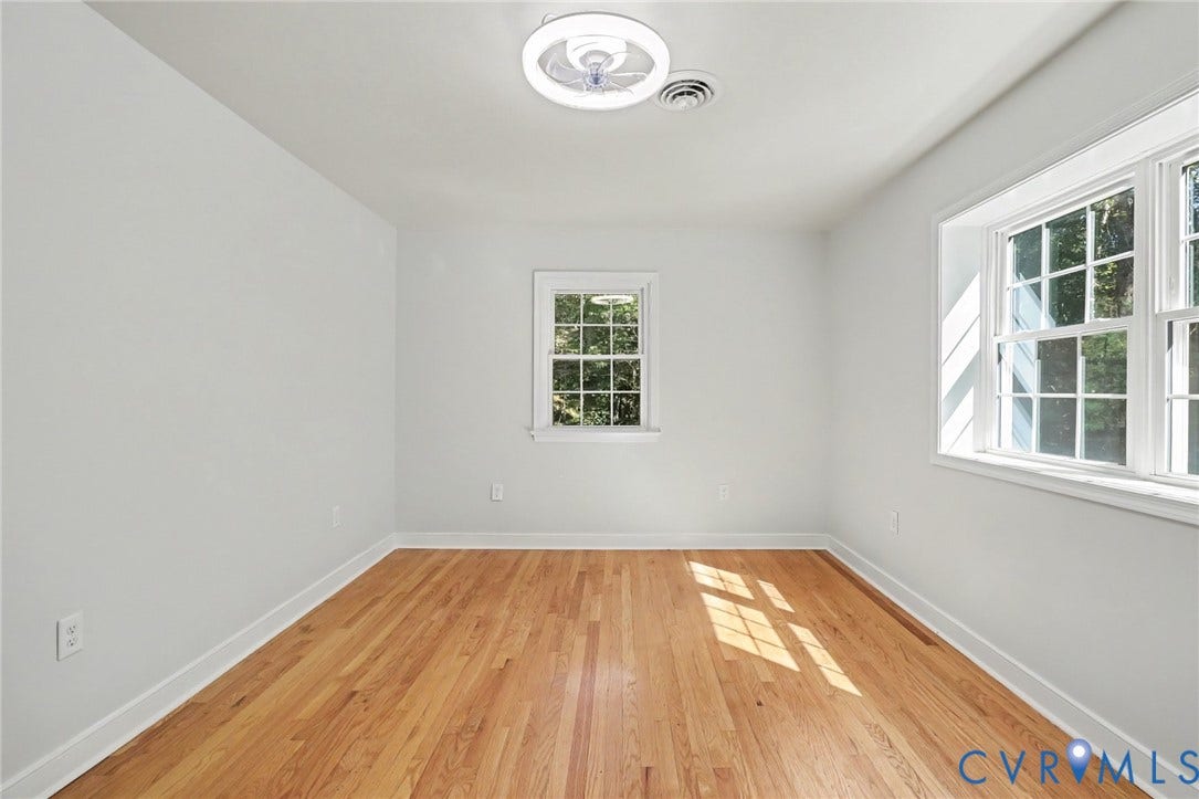 2511 Mill Road, Powhatan, VA 23139 Neutral interior space featuring wood-finish flooring, multi-pane windows, and a circular LED flush-mount ceiling light