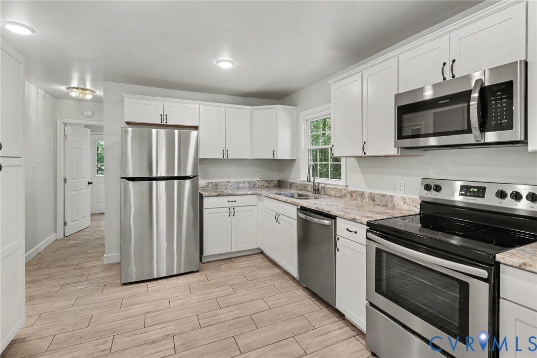 2511 Mill Road, Powhatan, VA 23139 Kitchen featuring white shaker-style cabinetry, stainless steel appliances, neutral stone-patterned countertops, and wood-finish tile flooring