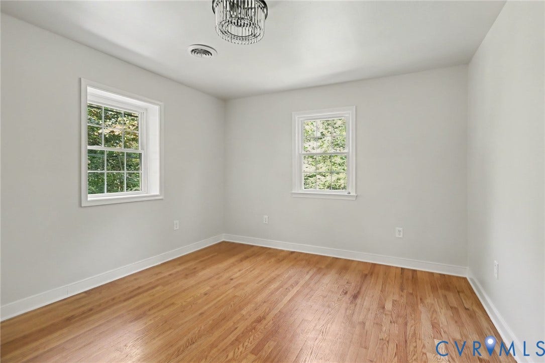 2511 Mill Road, Powhatan, VA 23139 Room featuring wood-finish flooring, two double-hung windows with muntin grids, and a central tiered crystal light fixture