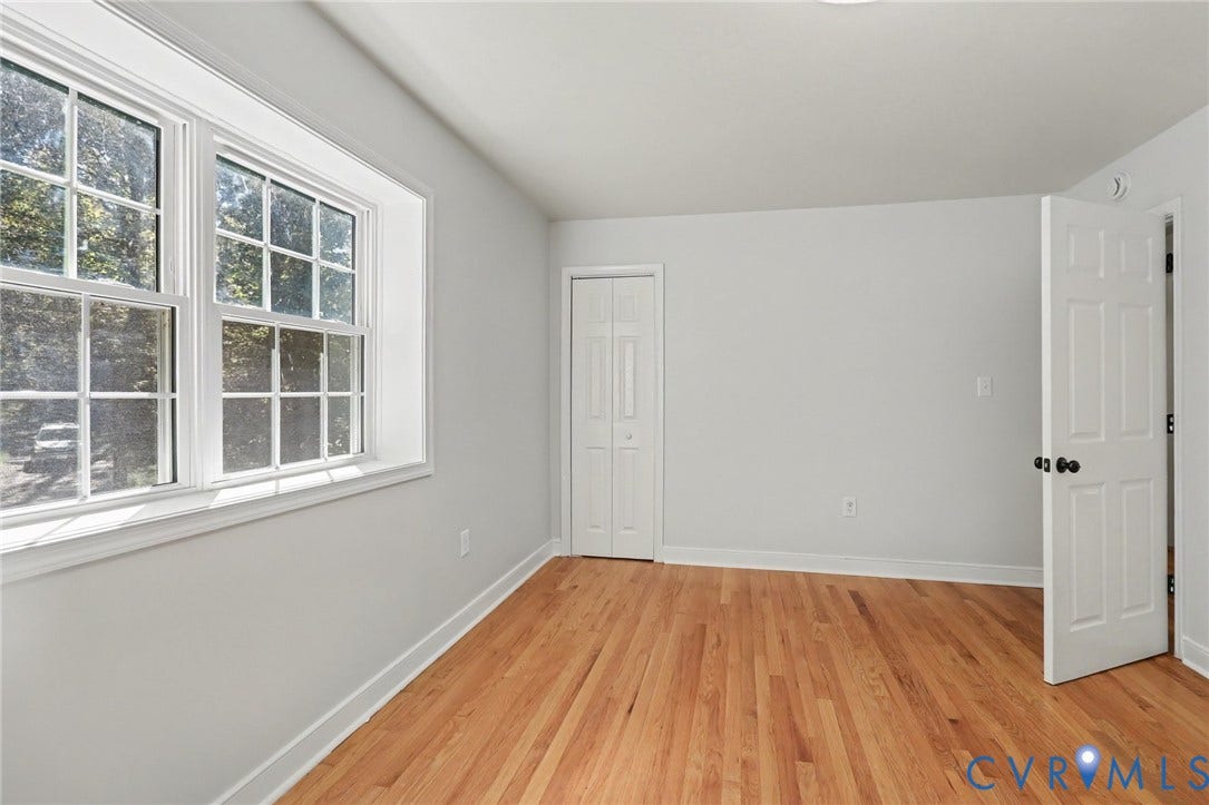 2511 Mill Road, Powhatan, VA 23139 Room featuring wood-finish flooring, multi-pane window, bi-fold closet doors, and a six-panel door with matte black hardware