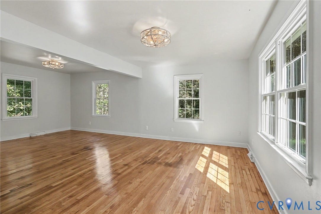 2511 Mill Road, Powhatan, VA 23139 Room featuring wood-finish flooring, white walls, multiple windows with grid detailing, and two circular metal flush-mount light fixtures