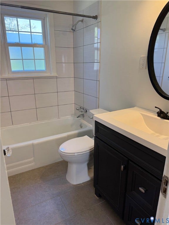 Bathroom featuring a white vanity cabinet with a contrasting countertop, integrated sink, matte black faucet, and large-format tile flooring