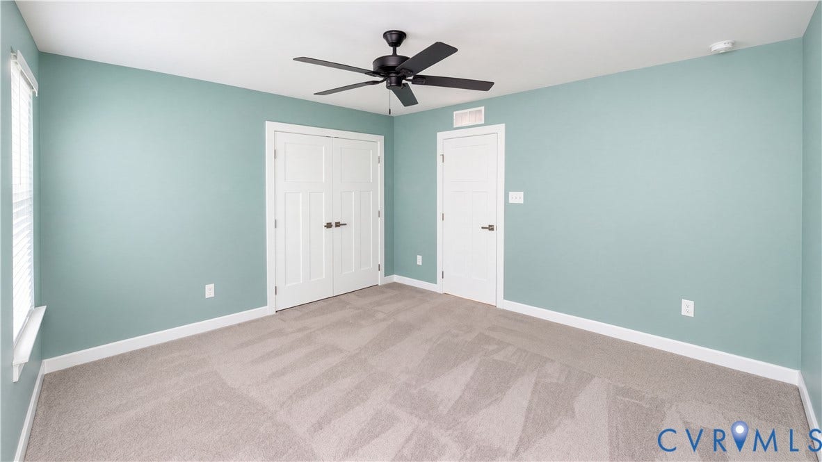 11500 Amara Drive, Chesterfield, VA 23838 Room featuring carpeted flooring, neutral wall paint, a ceiling fan with matte black finish, double-panel closet doors, and a single-panel interior door