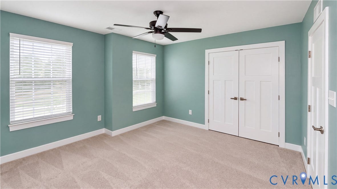 11500 Amara Drive, Chesterfield, VA 23838 Neutral-toned carpeting, dual-window configuration with horizontal blinds, central ceiling fan with integrated lighting, and white shaker-style double closet doors
