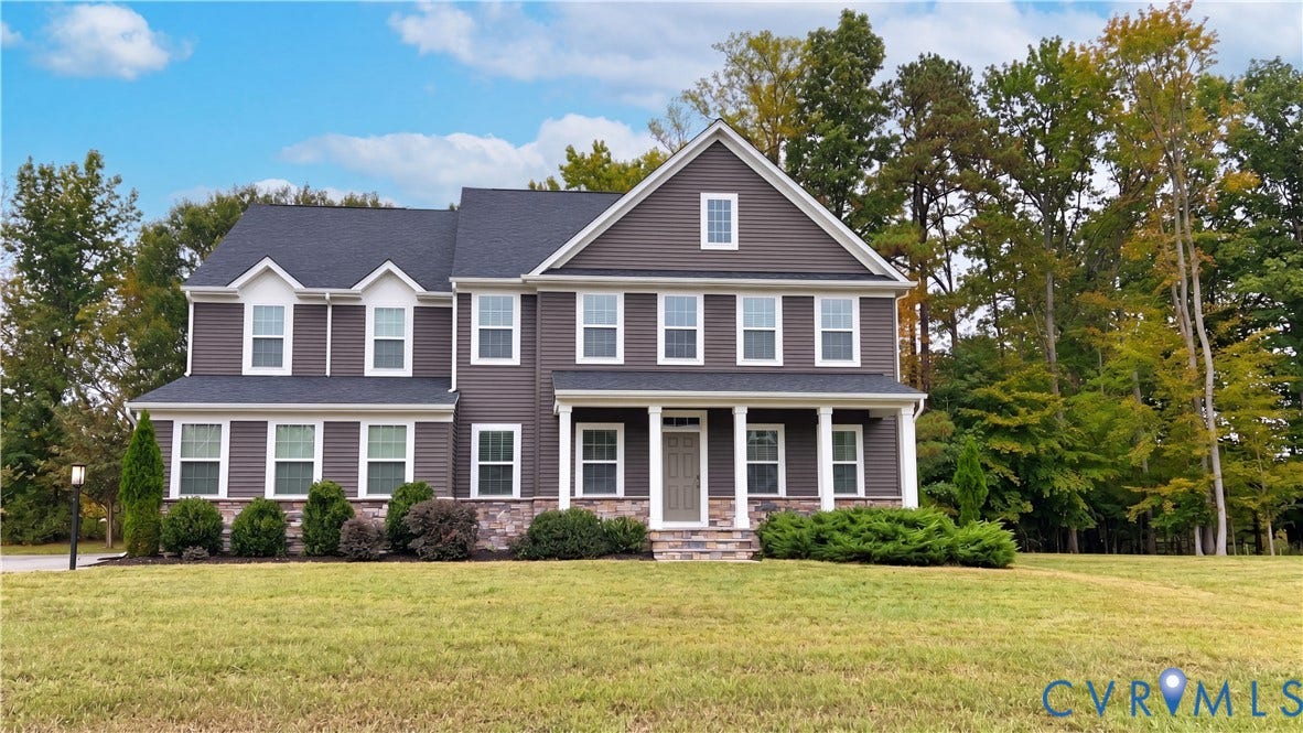 11500 Amara Drive, Chesterfield, VA 23838 Two-story residence featuring a dark horizontal-siding exterior, stone-veneer foundation, gabled rooflines, dormer windows, and a covered front porch with white columns